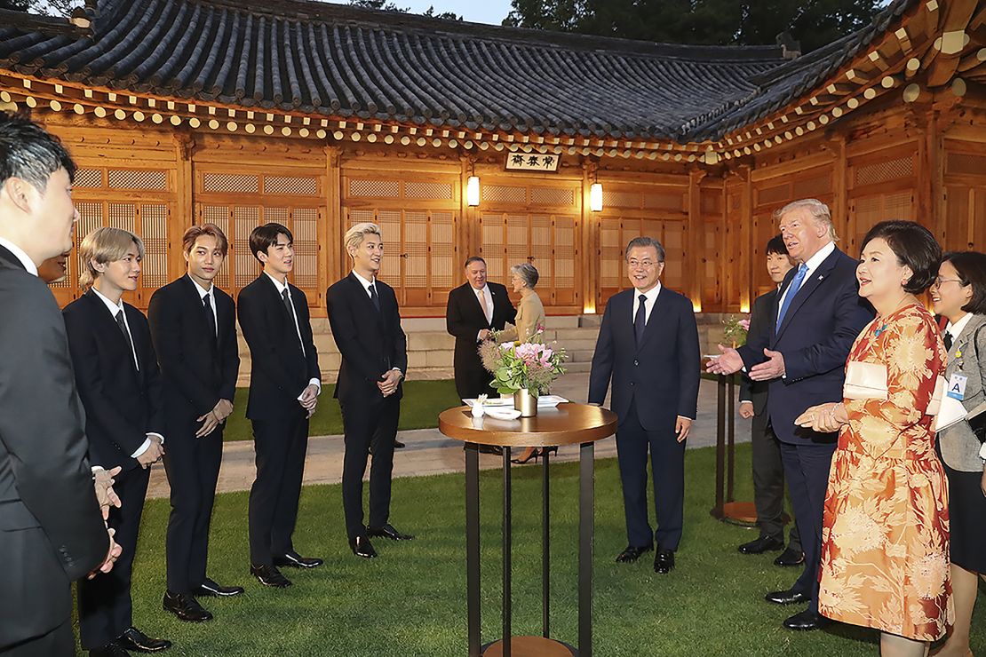 President Donald Trump talks with South Korean boy band EXO as South Korean President Moon Jae-in stands during a dinner at the presidential Blue House on June 29, 2019 in Seoul, South Korea. 