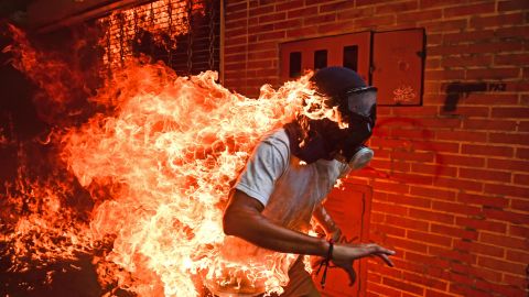 A demonstrator catches on fire during anti-government protests in Caracas, Venezuela, in May 2017. It happened as protesters clashed with police and the gas tank of a police motorbike exploded. Other photos from the scene showed the man being attended to with burns on his body.