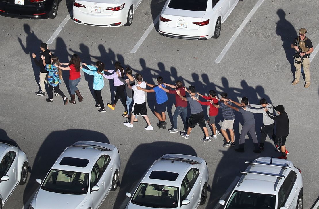 People are brought out of the Marjory Stoneman Douglas High School after a shooting at the school that reportedly killed 17 people on February 14, 2018 in Parkland, Florida.