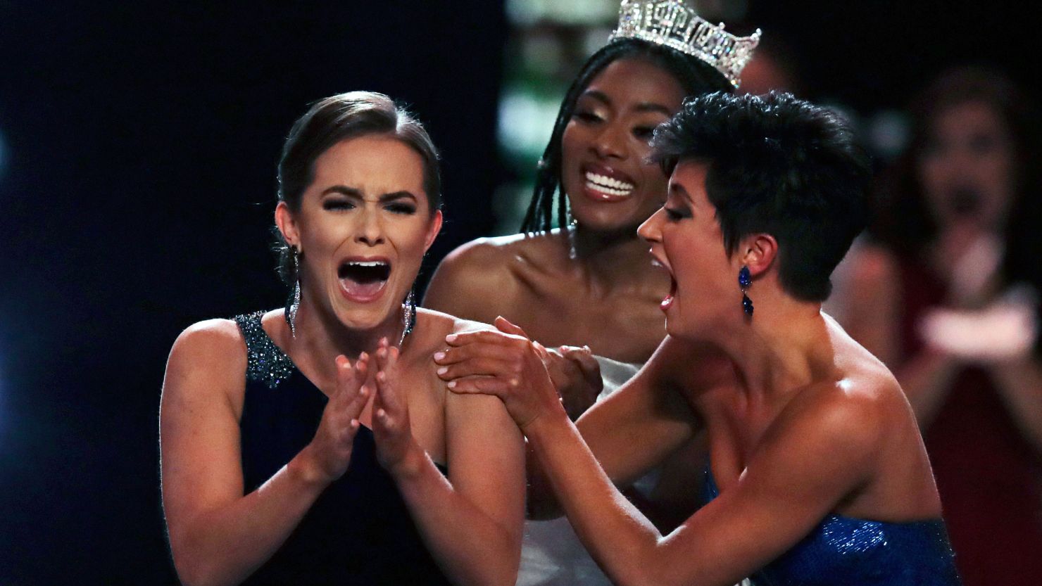 Camille Schrier, of Virginia, left, reacts after winning the Miss America competition while runner-up Miss Georgia Victoria Hill  2019 and Miss. America Nia Franklin congratulate her.