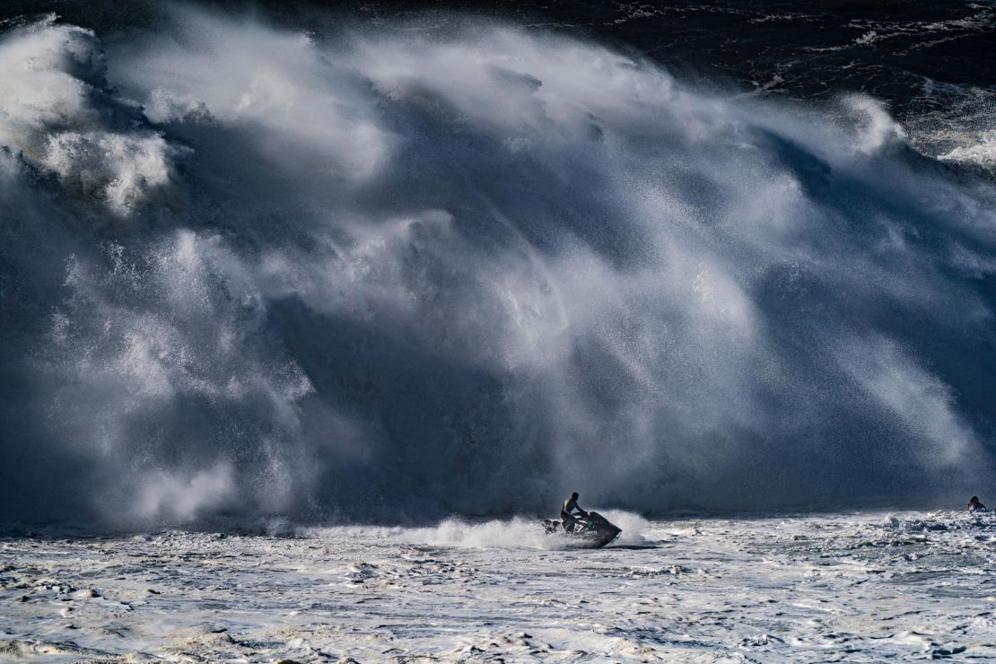 Big waves crash behind Nic von Rupp as he guides his jet ski to safety at Nazaré.