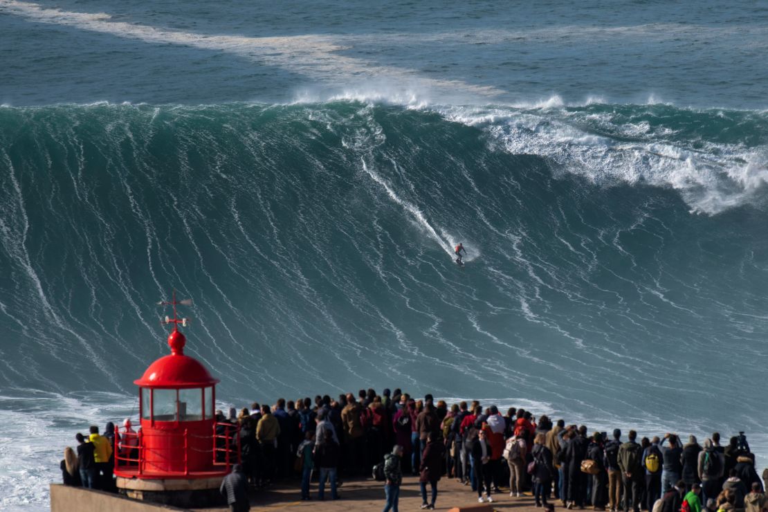Spectators gather at Nazaré's lighthouse to watch surfers tackle the monster waves.