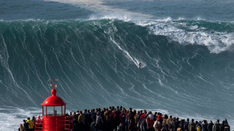 Spectators gather at Nazaré's lighthouse to watch surfers tackle the monster waves.