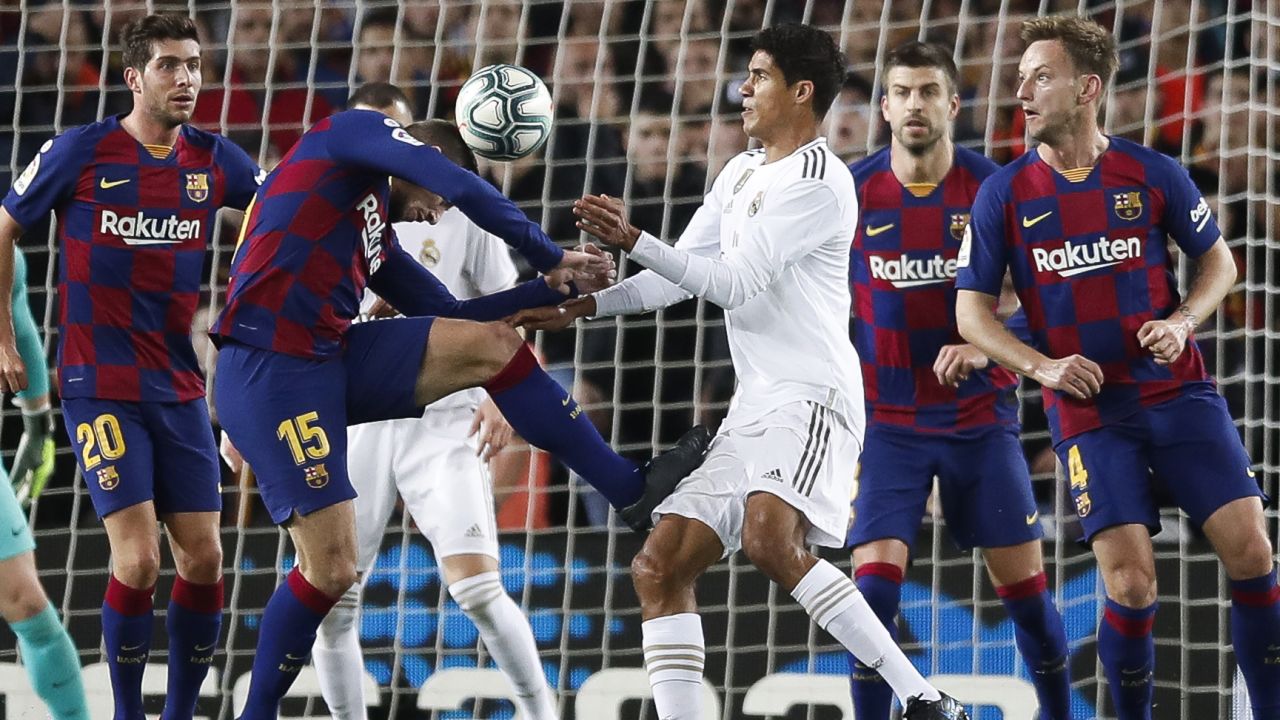 Raphael Varane is challenged by Clement Lenglet.