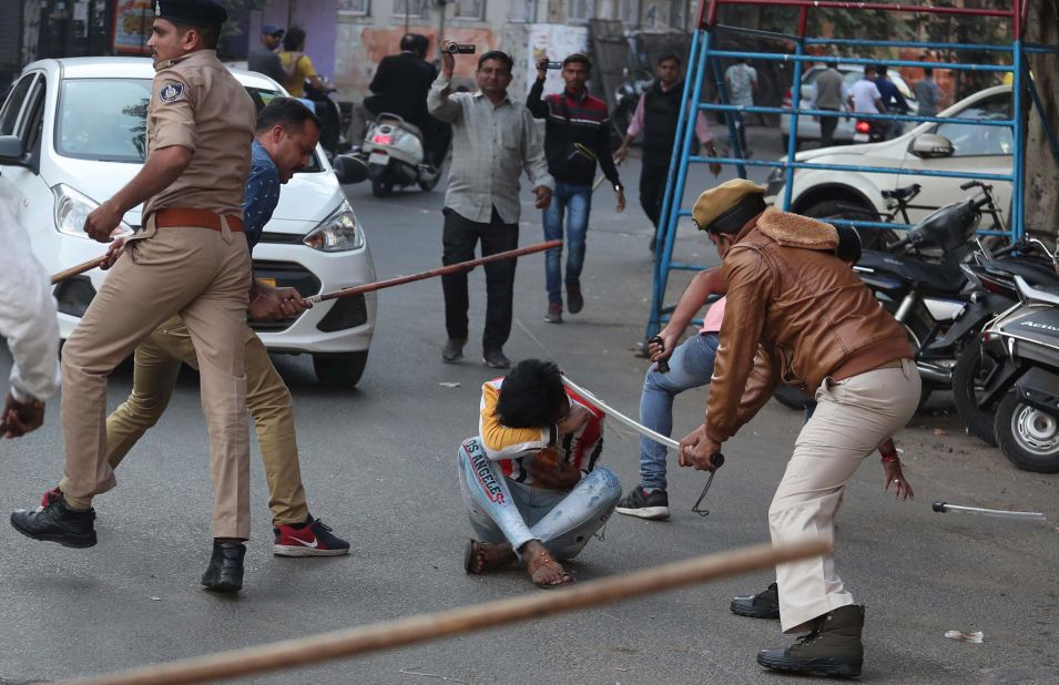 Policemen with batons charge a protester in Ahmedabad on Thursday, December 19.