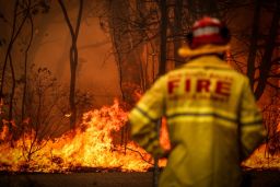  A Fire and Rescue personal watches a bushfire as it burns near homes on the outskirts of the town of Bilpin on December 19, 2019 in Sydney, Australia.