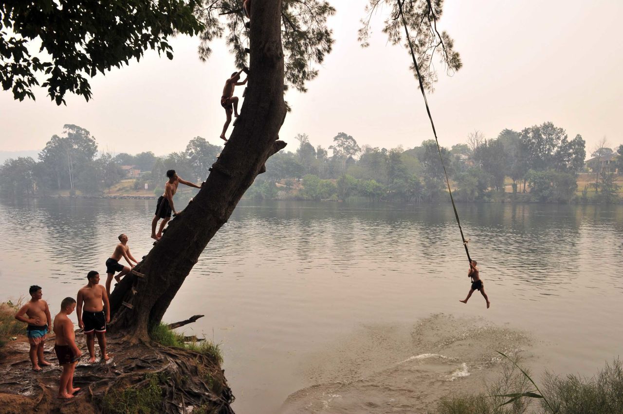 Children swing into the Penrith river during a heatwave in Sydney on December 19.