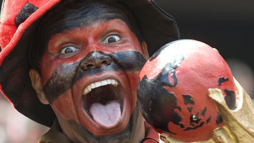 A Flamengo supporter cheers his team holding a fake Fifa World Cup before the start of the Brazilian Championship final match against Gremio, at the Maracana stadium on December 06, 2009 in Rio de Janeiro, Brazil. AFP PHOTO/Antonio Scorza (Photo credit should read ANTONIO SCORZA/AFP via Getty Images)