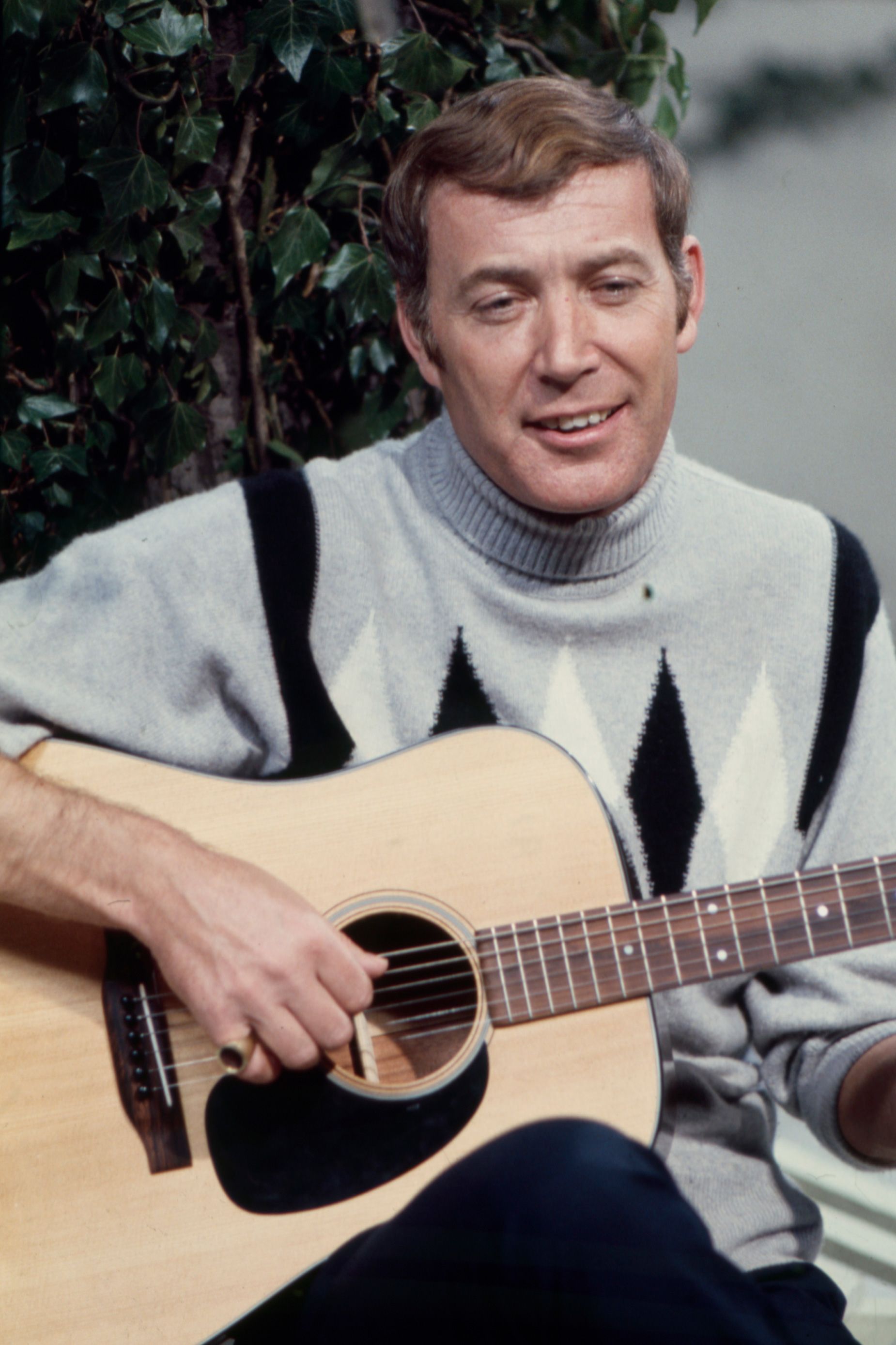 Val Doonican performing in a festive sweater on an episode of his ABC series 