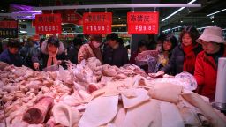 This photo taken on December 19, 2019 shows people trying to buy meat at a newly-opened supermarket in Binzhou, in China's eastern Shandong Province. 