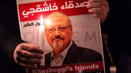 TOPSHOT - A demonstrator holds a poster picturing Saudi journalist Jamal Khashoggi and a lightened candle during a gathering outside the Saudi Arabia consulate in Istanbul, on October 25, 2018. - Jamal Khashoggi, a Washington Post contributor, was killed on October 2, 2018 after a visit to the Saudi consulate in Istanbul to obtain paperwork before marrying his Turkish fiancee. (Photo by Yasin AKGUL / AFP)        (Photo credit should read YASIN AKGUL/AFP via Getty Images)