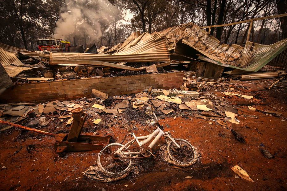 A charred bicycle lies on the ground in front of a house destroyed by bushfires on the outskirts of Bargo on December 21.