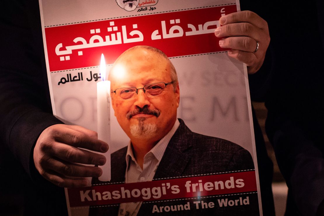 A demonstrator holds a poster picturing Saudi journalist Jamal Khashoggi and a candle during a gathering outside the Saudi Arabia consulate in Istanbul, on October 25, 2018. 