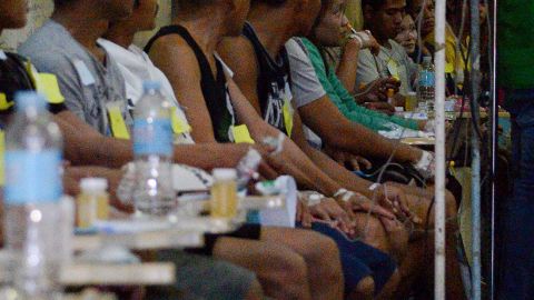 Victims who fell ill after drinking lambanog wait for treatment at the Philippine General Hospital in Manila on December 23, 2019.