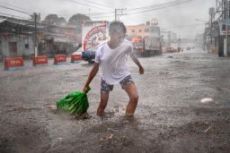 A resident clears garbage floating in a flooded highway during the onslaught of Typhoon Kammuri on December 3, 2019 in Lipa town, Batangas province, Philippines. 
