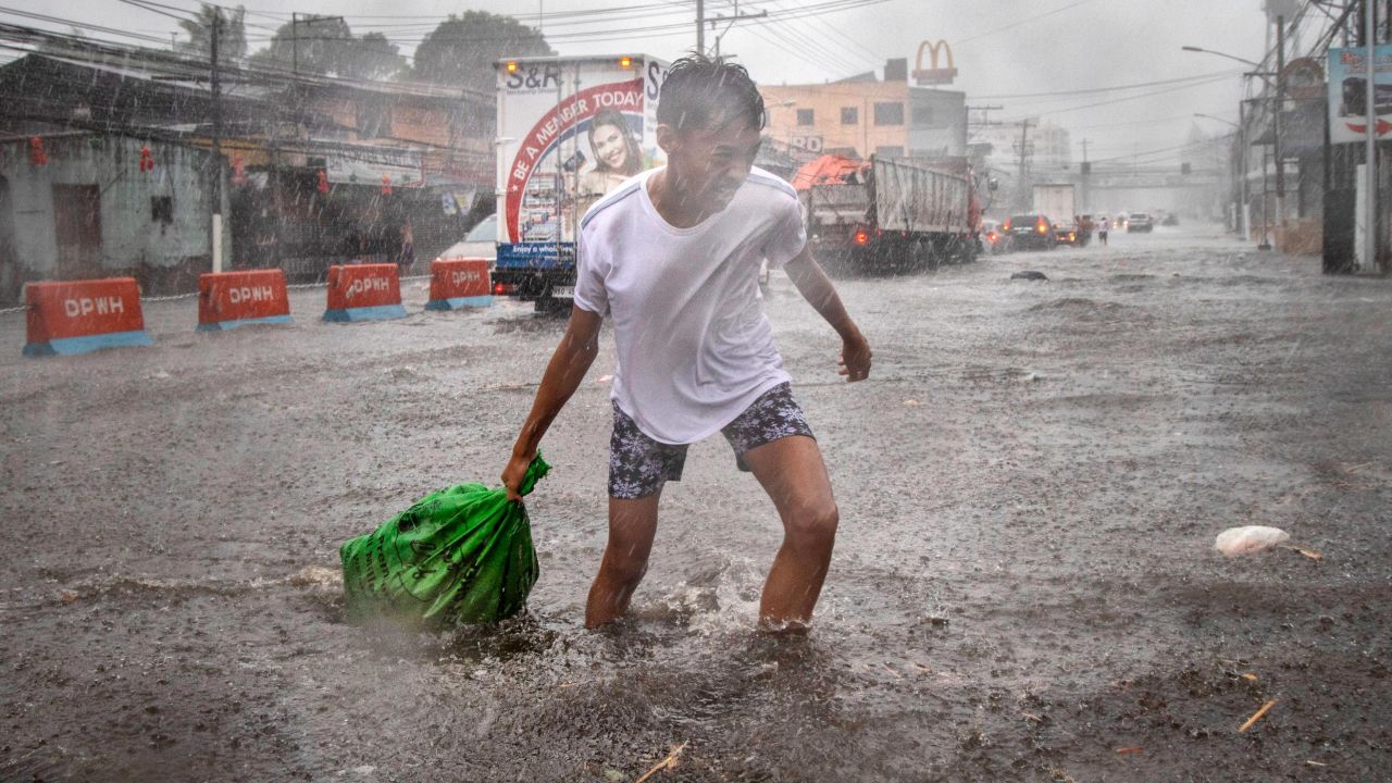 A resident clears garbage floating in a flooded highway during the onslaught of Typhoon Kammuri on December 3, 2019 in Lipa town, Batangas province, Philippines. 
