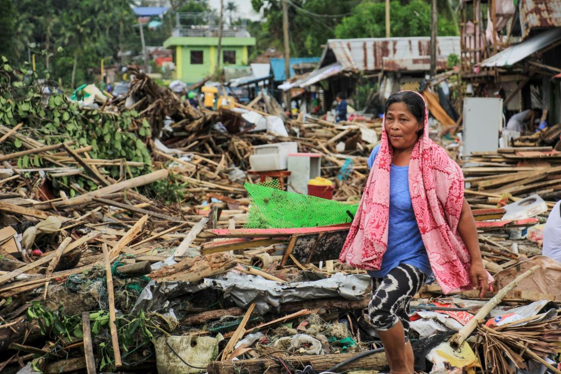 A resident walks past debris from her destroyed houses after Typhoon Kammuri hit the city of Sorsogon, south of of Manila.
