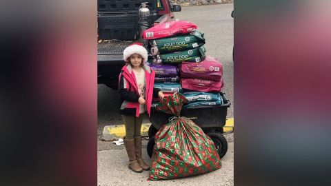 Landyn Wadsworth, 8, stands next to her Christmas present -- 600 pounds of  pet food for a local shelter.