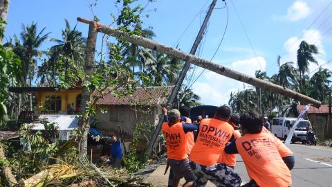 Workers pull a fallen electric pylon damaged at the height of Typhoon Phanfone in Salcedo town in Eastern Samar province on December 26, 2019.