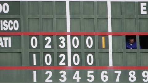 A scoreboard operator watches the game between the Chicago Cubs and the Cincinnati Reds.
