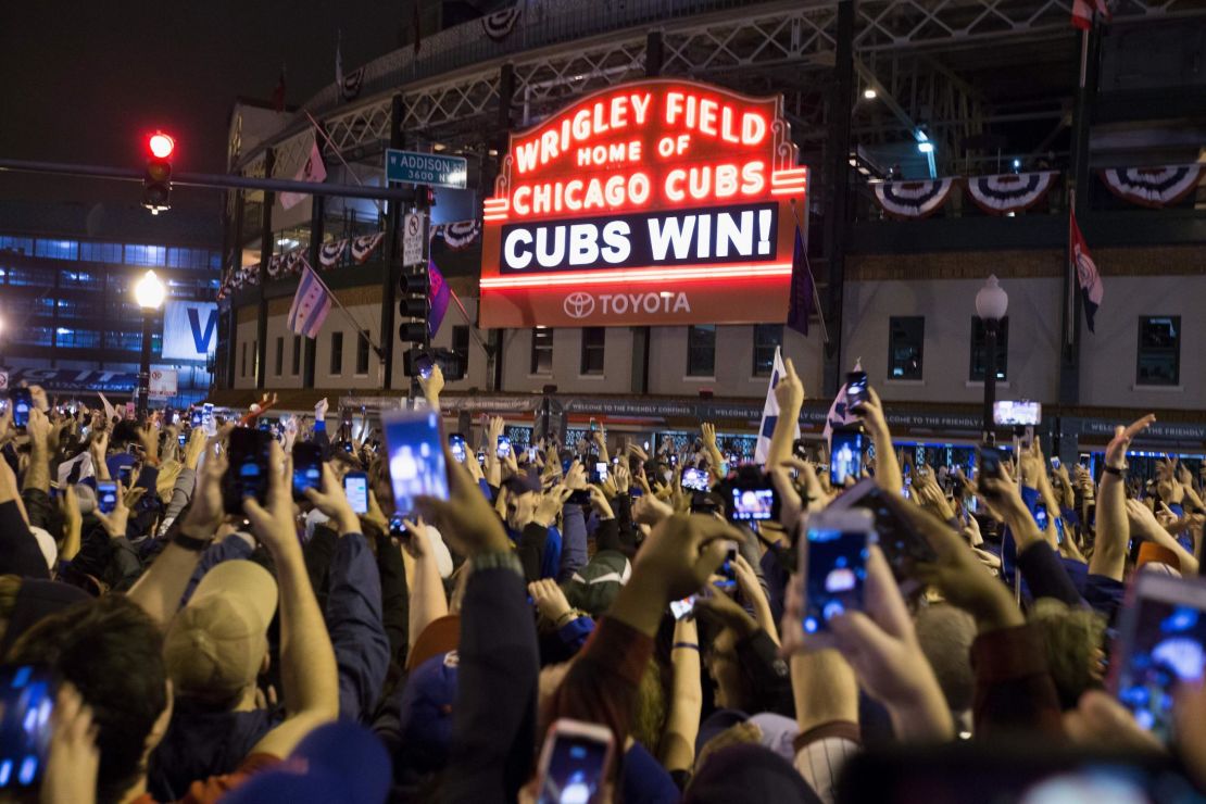 Chicago fans celebrate the Chicago Cubs' 8-7 victory over the Cleveland Indians outside Wrigley Field.