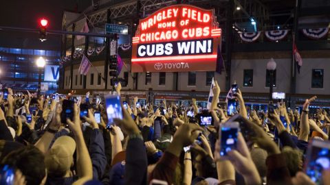 Chicago fans celebrate the Chicago Cubs' 8-7 victory over the Cleveland Indians outside Wrigley Field.