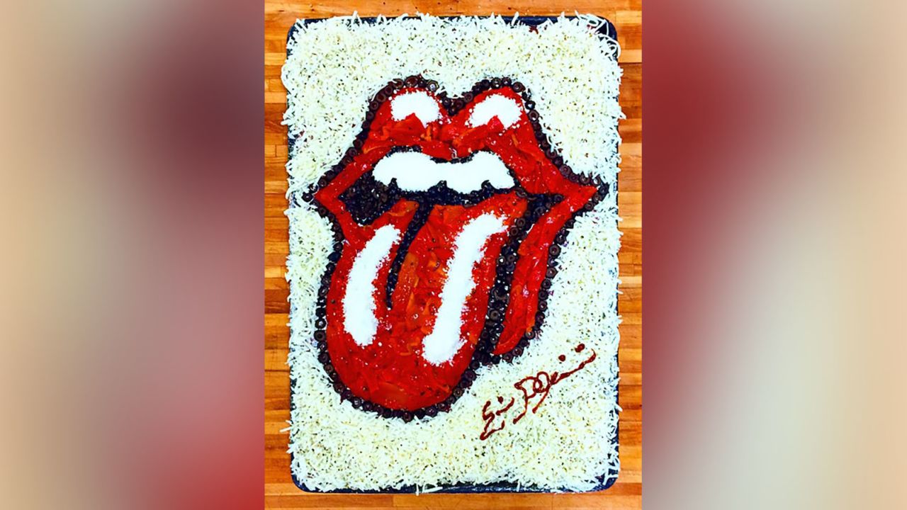 The Rolling Stones logo pizza is made with red bell peppers, black olives, sauce and cheese.