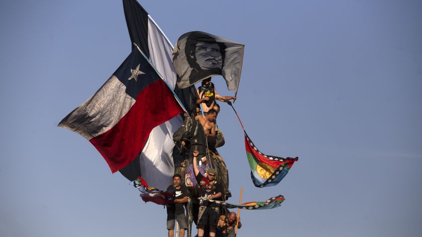 Demonstrators wave Chilean and Mapuche flags during a protest against the government of Chilean President Sebastian Pinera in Santiago, on December 27, 2019. - Chile has been rocked by months of protests that began with strikes over metro fare hikes and quickly escalated into the most severe outbreak of social unrest since the end of the dictatorship of Augusto Pinochet nearly 30 years ago. (Photo by CLAUDIO REYES / AFP) (Photo by CLAUDIO REYES/AFP via Getty Images)