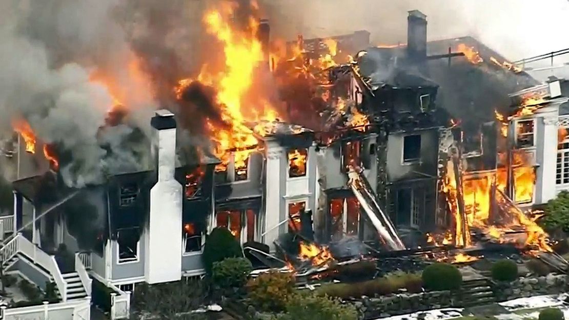 The 6,500-square-foot house was engulfed in flames as firefighters battled to bring it under control.