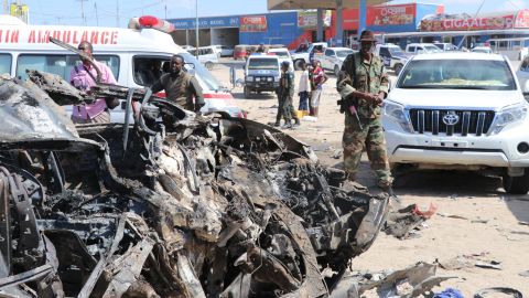 A soldier is seen next to the wreckage of car that was damaged during the suicide attack in Mogadishu on Saturday.
