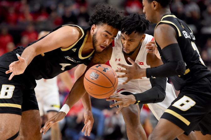 Bryant University's Nathaniel Stokes, left, and Maryland Terrapins' Donta Scott, fight for the ball during a game in College Park, Maryland, on Sunday, December 29.