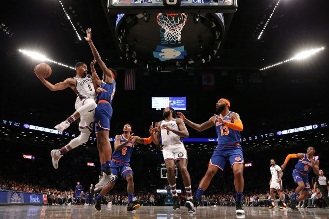 Brooklyn Nets point guard Spencer Dinwiddie drives to the basket against New York Knicks' Mitchell Robinson, during an NBA game in Brooklyn, New York, on Thursday, December 26.