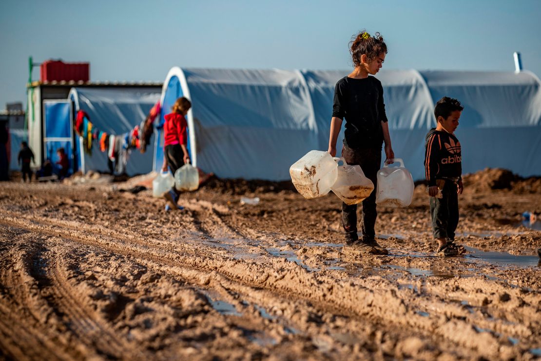 Children carry jugs to fill with water in the Washukanni camp for internally displaced people in northeastern Syria.