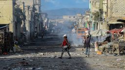 TOPSHOT - People walk on the deserted road ahead of gang shootings in downtown in Port-au-Prince, on December 20, 2019. (Photo by CHANDAN KHANNA / AFP) (Photo by CHANDAN KHANNA/AFP via Getty Images)