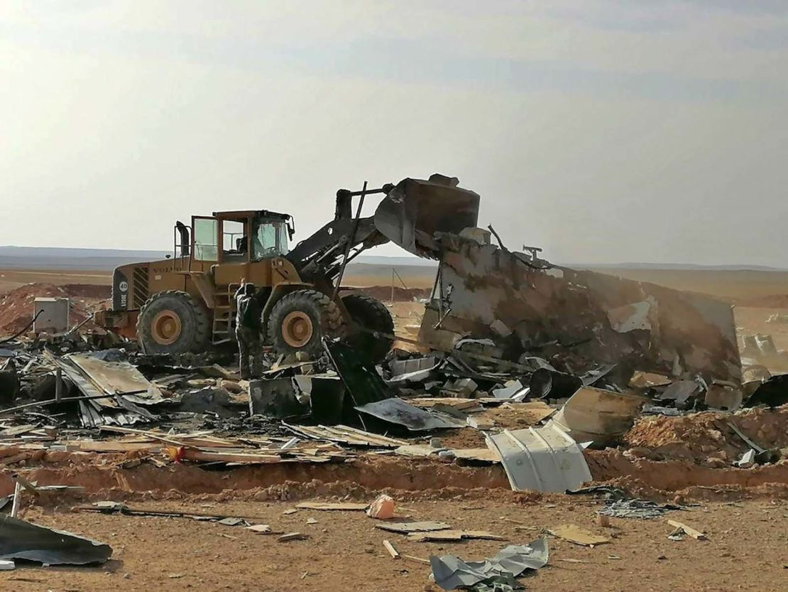 Fighters with the Kataib Hezbollah militia search for bodies in the aftermath of a US airstrike.