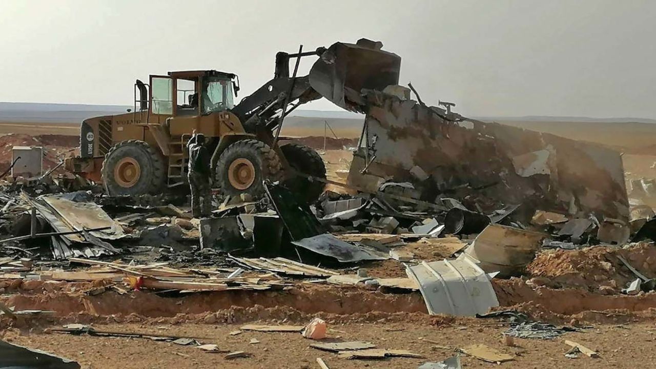 Fighters with the Kataib Hezbollah militia search for bodies in the aftermath of a US airstrike.
