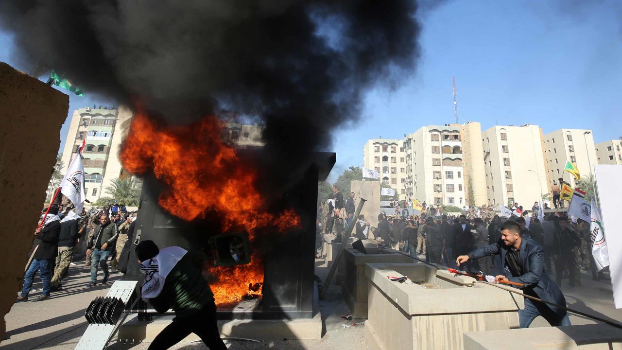Iraqi protesters set a sentry box ablaze in front of the US embassy in Baghdad on Tuesday.