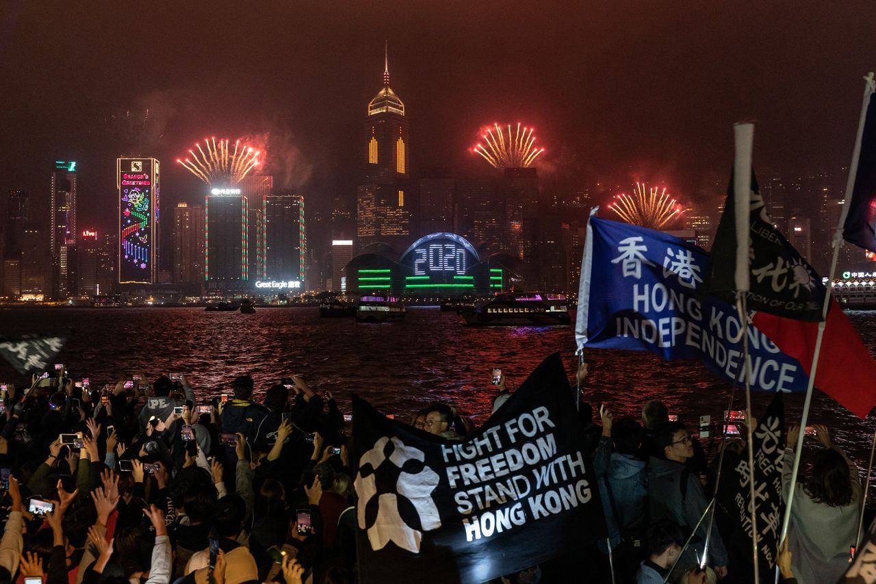 Pro-democracy supporters wave flags and shout slogans during a countdown party in the Tsim Sha Tsui district in Hong Kong.