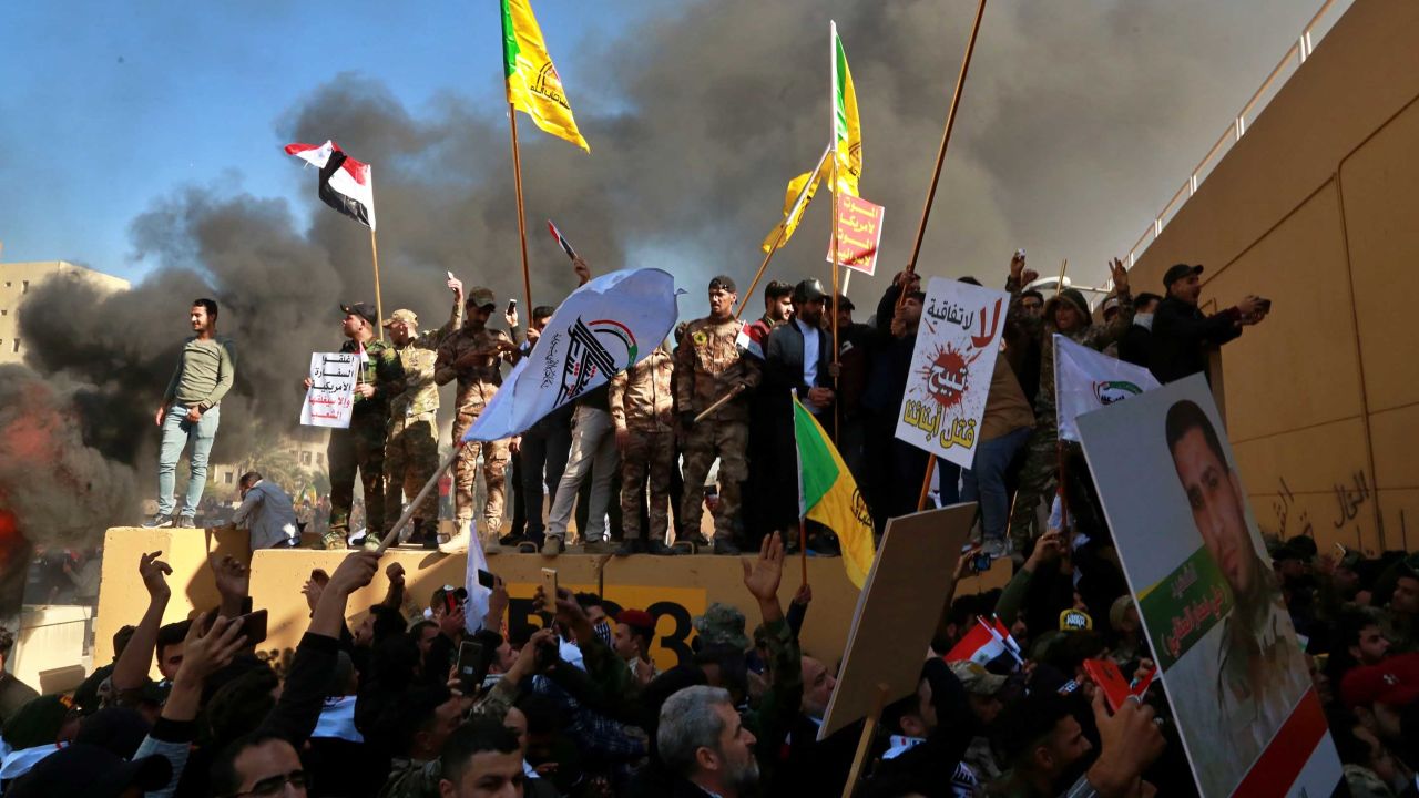 Protesters burn property in front of the US Embassy compound, in Baghdad, Iraq, Tuesday.