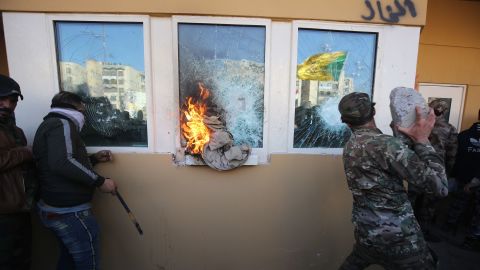 Protesters smash the bullet-proof glass of the US Embassy's windows in Baghdad on December 31.