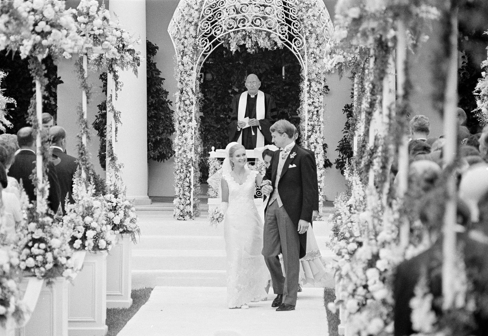The former Tricia Nixon and her husband Edward Finch Cox, walk from the altar at the White House Rose Garden after their marriage, June 12, 1971. Obscured by the bride and groom are matron of honor Julie Nixon Eisenhower and best man Howard E. Cox Jr. In the background is the Rev. Dr. Edward G. Latch, chaplain of the U.S. House of Representatives, who performed the wedding. (AP Photo, File)