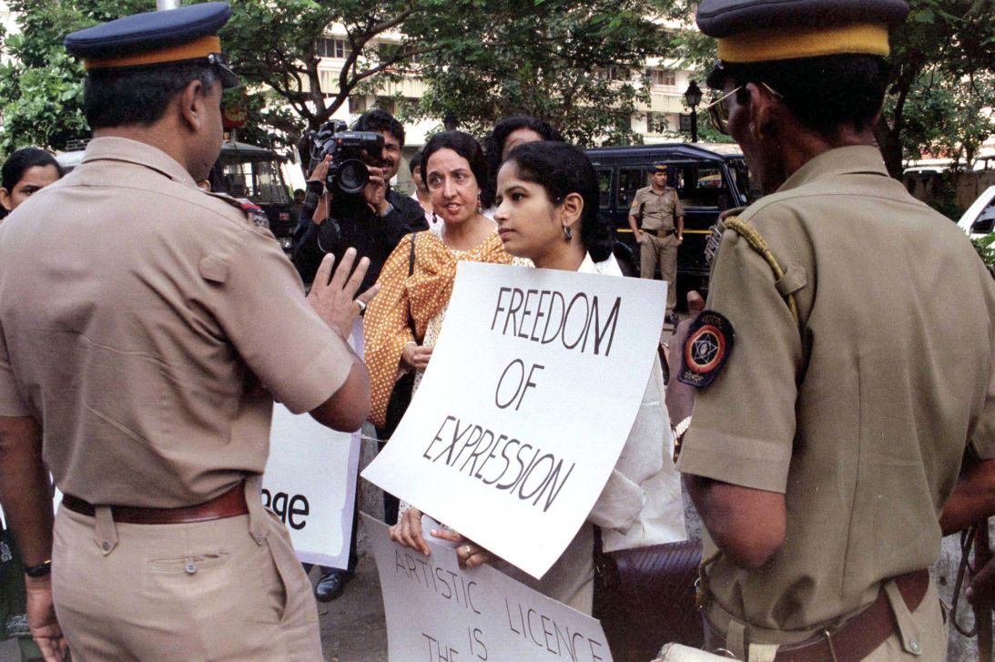 Police confront one of Husain's supporters at a demonstration outside his Mumbai home after the police filed charges of obscenity against him.