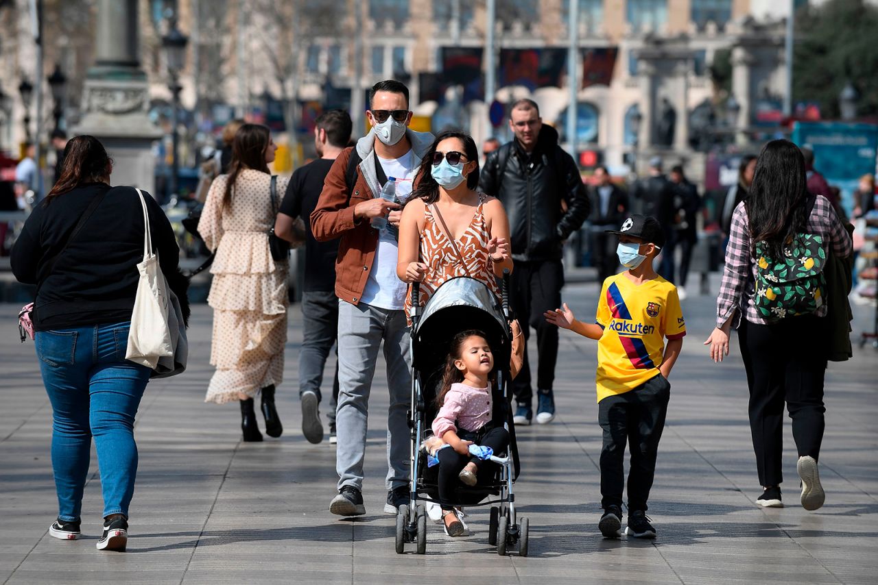 A family wearing protective masks walk in Barcelona on March 13.