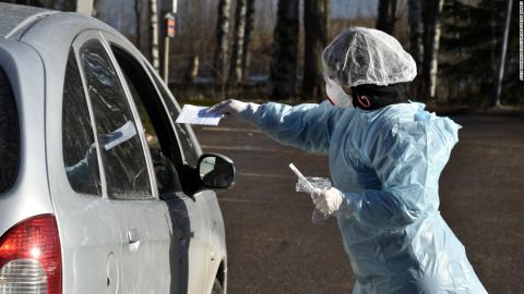 Medical workers take samples from patients at a coronavirus drive-in test center in Espoo, Finland in April.
