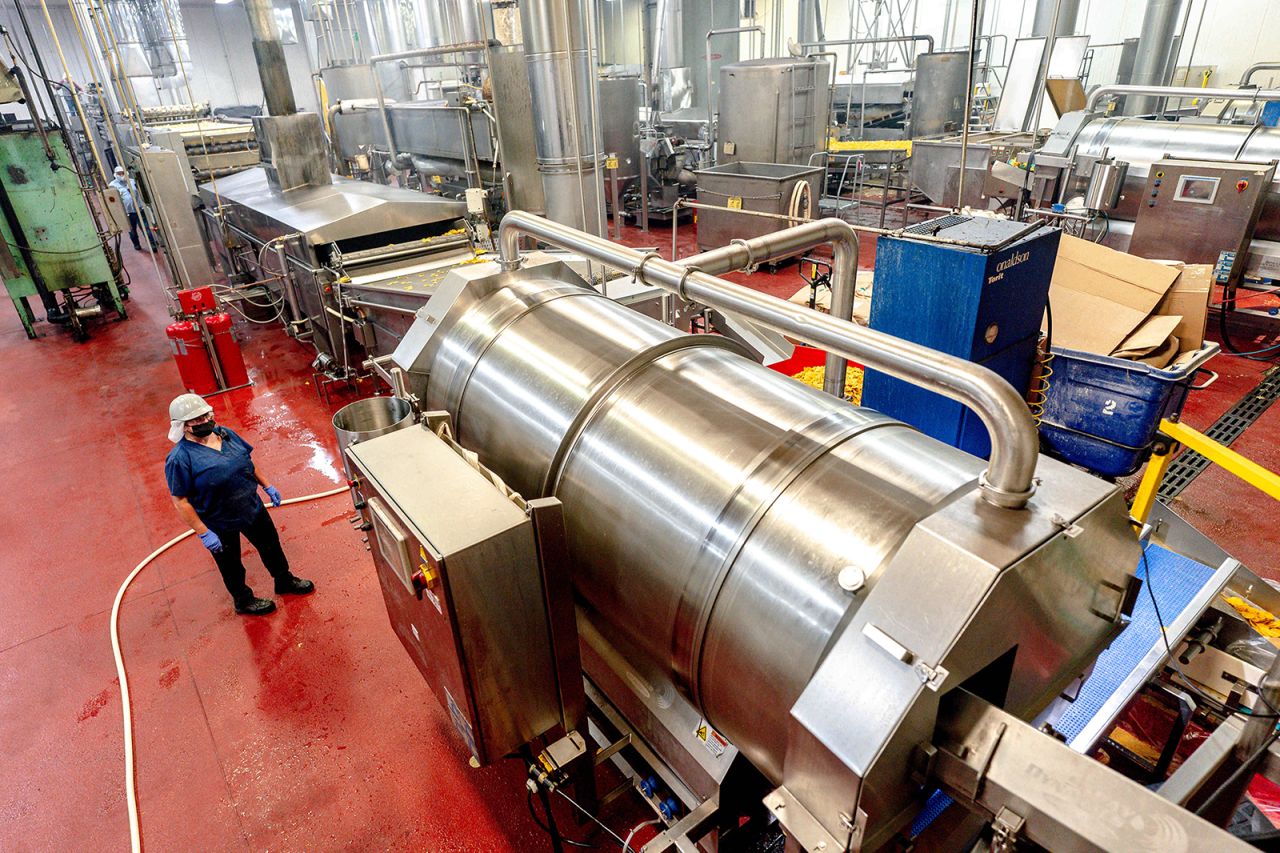 A worker monitors the processing of tortilla chips at a factory in San Bernardino on June 29.