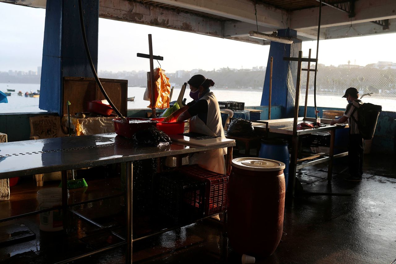 A vendor skins fish inside an empty market in Lima, Peru, on May 1.