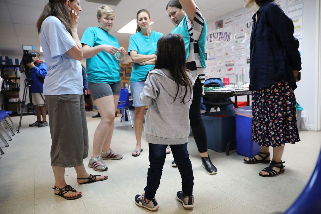 Jenquel, who recently crossed the U.S., Mexico border with her mother and siblings, speaks with volunteers at the Catholic Charities Humanitarian Respite Center on June 21, 2018 in McAllen, Texas. 