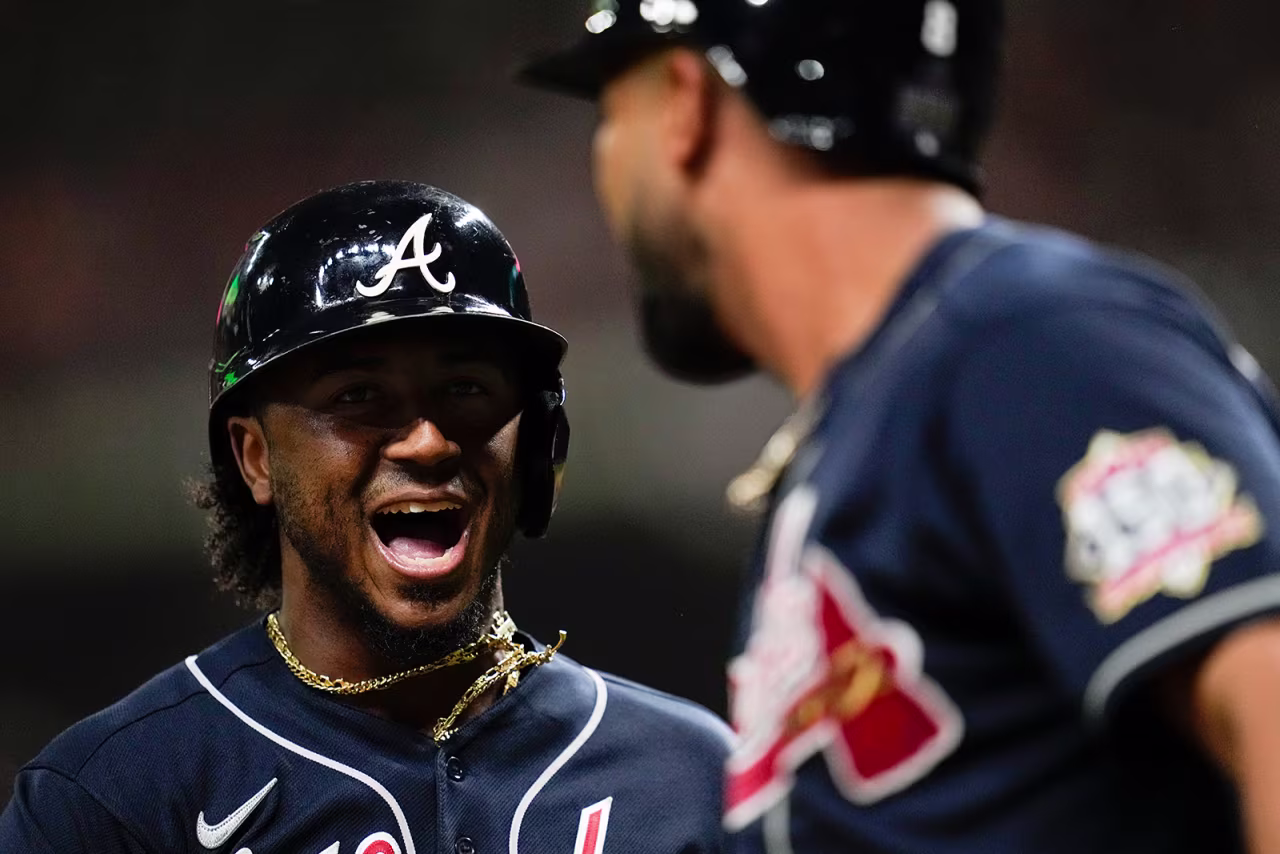 Atlanta Braves' Ozzie Albies celebrates after scoring on a double by Austin Riley during the first inning.