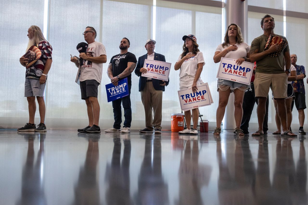 Supporters of Donald Trump place their hands over their hearts during the national anthem at a campaign rally at the Georgia State Convocation Center in Atlanta, Georgia, on August 3.