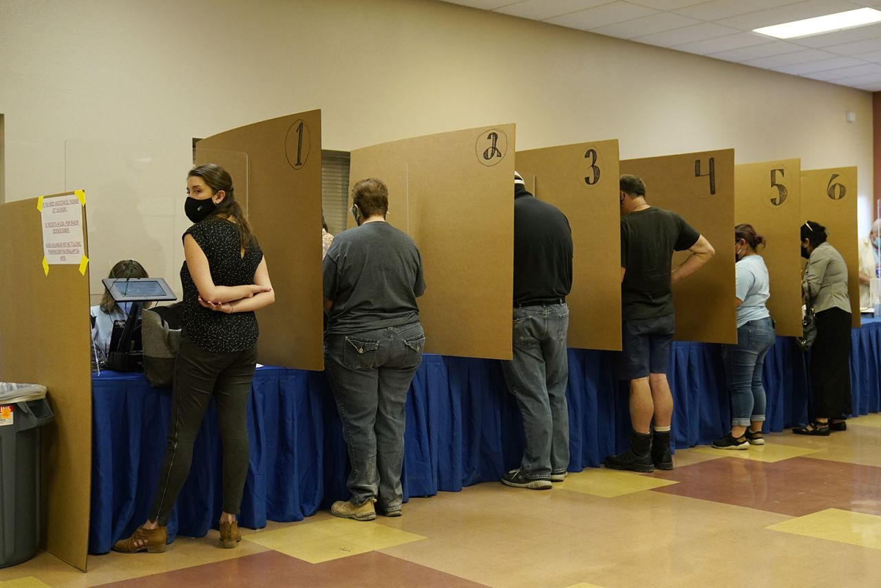 In this Oct. 30, 2020 file photo people prepare to vote at a polling place on the final day of early voting, in Las Vegas. 